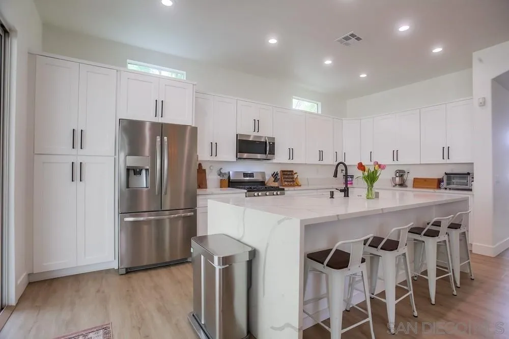2322 Byron Place Carlsbad, CA 92008 - Photo 12 of 56 a kitchen with stainless steel appliances a refrigerator stove microwave and cabinets