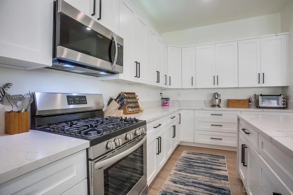 2322 Byron Place Carlsbad, CA 92008 - Photo 13 of 56 a kitchen with stainless steel appliances granite countertop a stove a microwave and cabinets