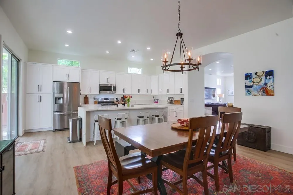 2322 Byron Place Carlsbad, CA 92008 - Photo 17 of 56 a dining room with stainless steel appliances kitchen island granite countertop a dining table chairs and a refrigerator