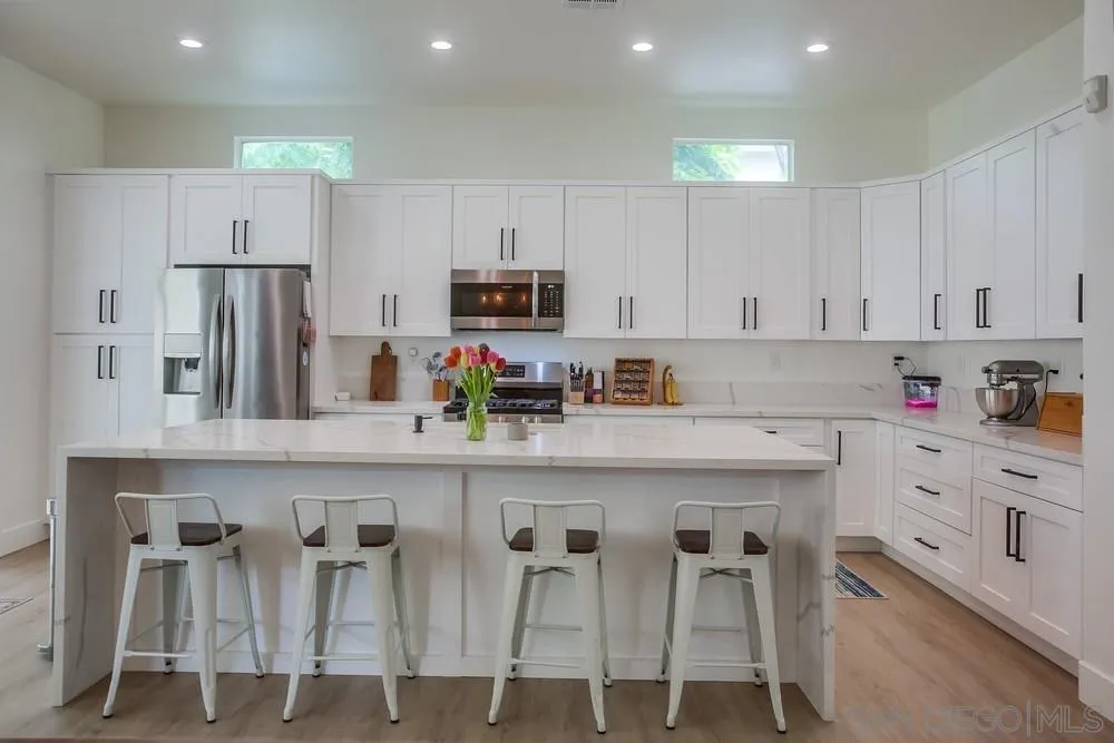 2322 Byron Place Carlsbad, CA 92008 - Photo 18 of 56 a kitchen with white cabinets and stainless steel appliances
