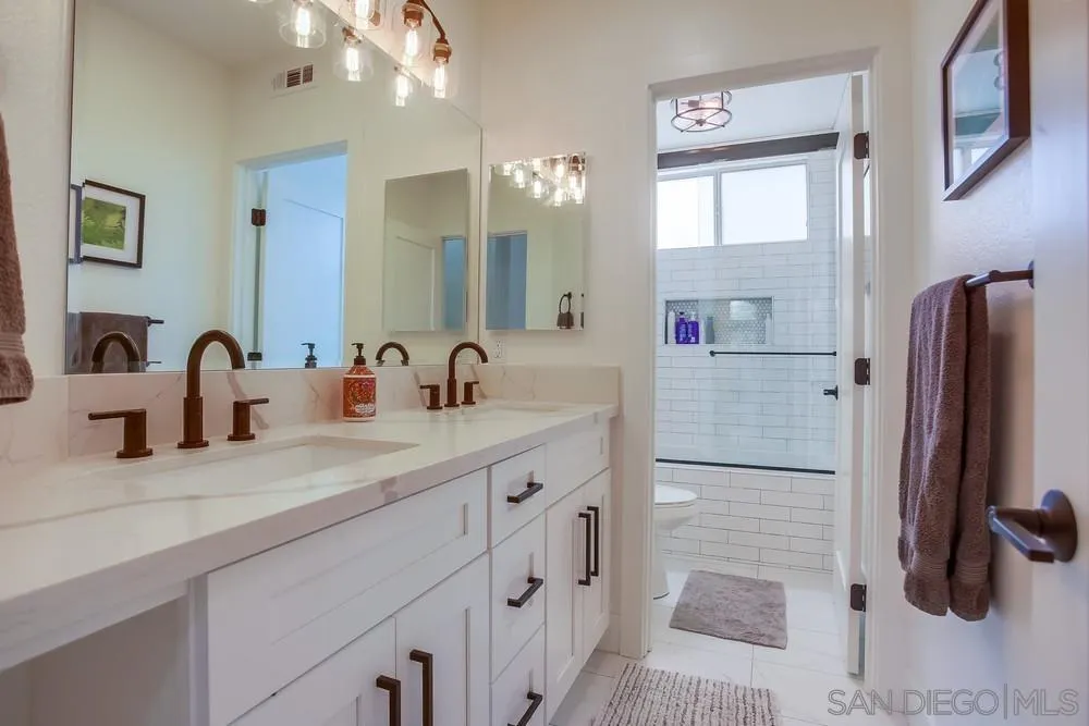 2322 Byron Place Carlsbad, CA 92008 - Photo 28 of 56 a bathroom with a double vanity sink a mirror and a shower