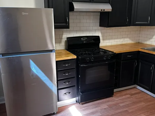 a kitchen with granite countertop white cabinets and black appliances