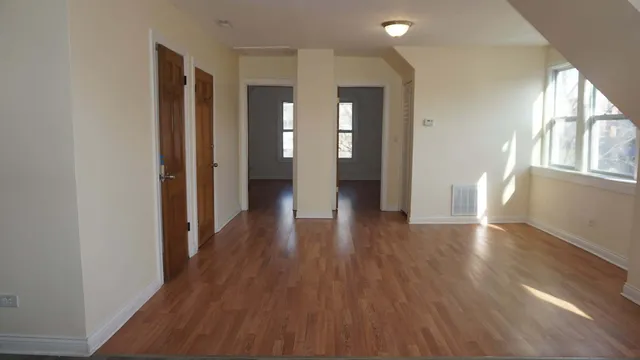 a view of a hallway with wooden floor and windows