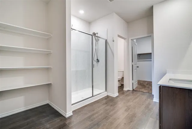 a view of an empty room with wooden floor and entryway