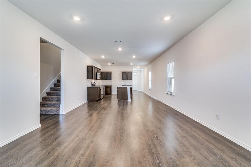 3025 Frazier Street Forney, TX 75126 - Photo 7 of 25 a view of a kitchen with a fridge and wooden floor