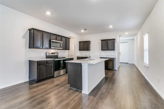a kitchen with stainless steel appliances kitchen island wooden cabinets and granite counter tops