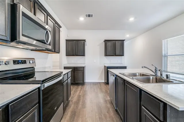 a kitchen with stainless steel appliances granite countertop a sink stove and microwave