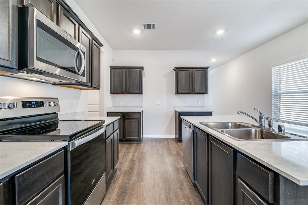 3025 Frazier Street Forney, TX 75126 - Photo 10 of 25 a kitchen with stainless steel appliances granite countertop a sink stove and microwave