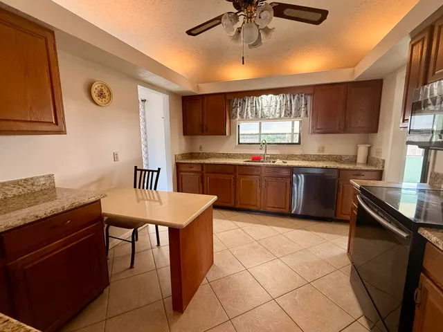 a kitchen with stainless steel appliances granite countertop a sink counter space cabinets and a window