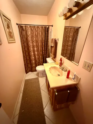 a bathroom with a sink and mirror with bathtub