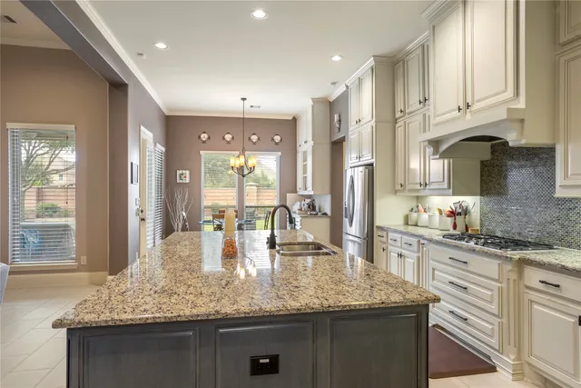 a kitchen with kitchen island granite countertop a large counter top space appliances and cabinets