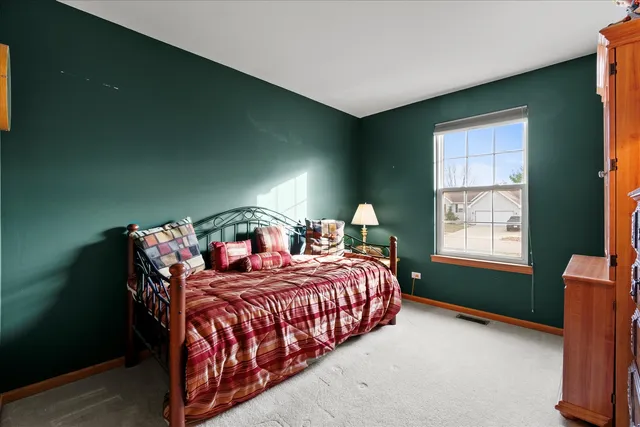 a bedroom with a bed lamp and a window