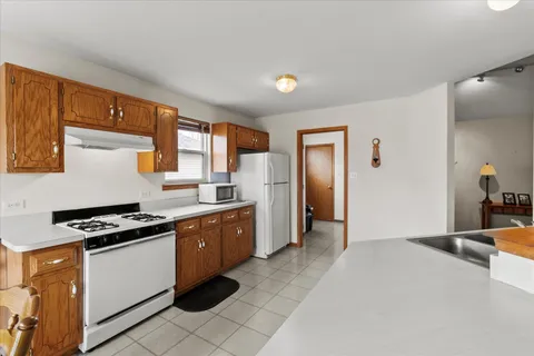 a kitchen with stainless steel appliances granite countertop a stove a sink and a refrigerator