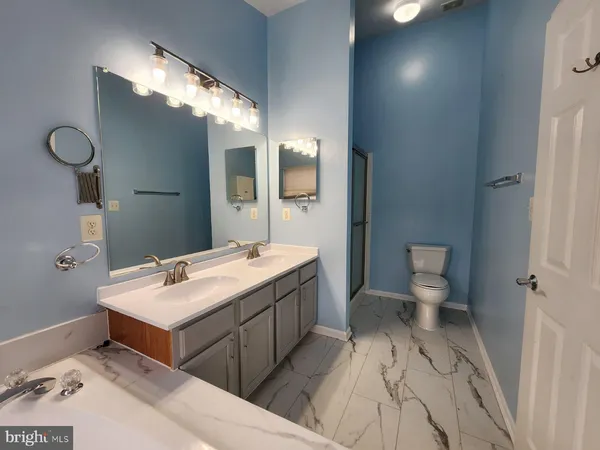 a spacious bathroom with a sink toilet and mirror