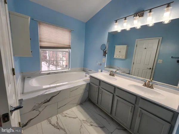 a bathroom with a large tub sink and mirror