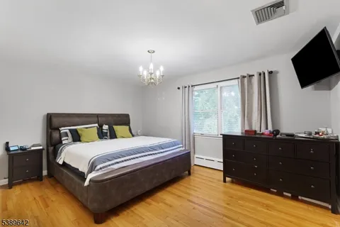a bedroom with a bed window and a flat screen tv