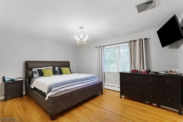 a bedroom with a bed window and a flat screen tv