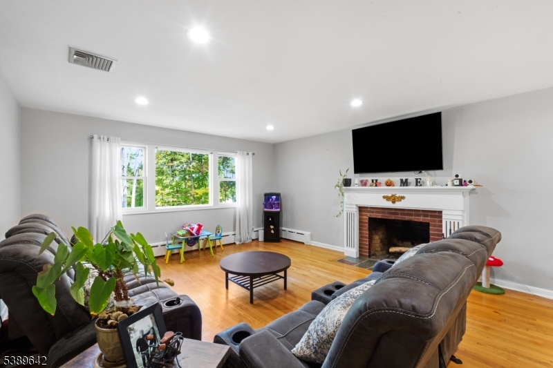 202 Mt Horeb Road Warren, NJ 07059 - Photo 4 of 23 a living room with furniture a fireplace and a flat screen tv