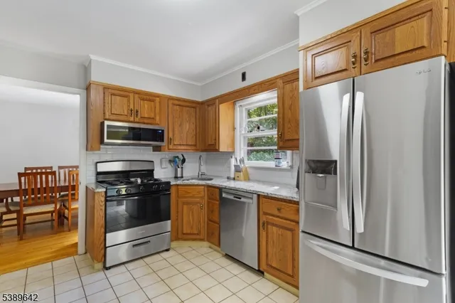 a kitchen with stainless steel appliances granite countertop a refrigerator and a stove top oven