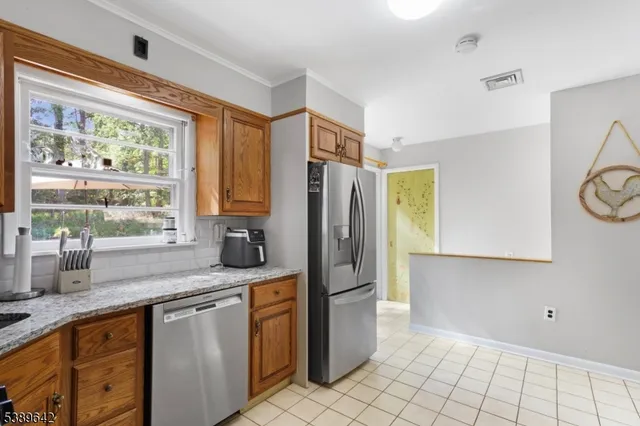 a kitchen with stainless steel appliances granite countertop a refrigerator and a sink