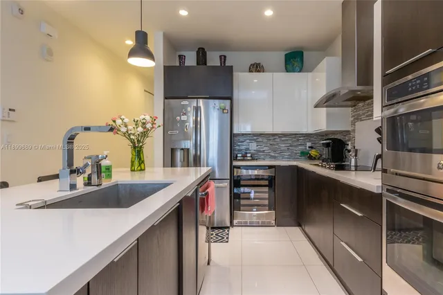 a kitchen with stainless steel appliances a sink and a refrigerator