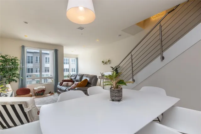a dining room with furniture and potted plants