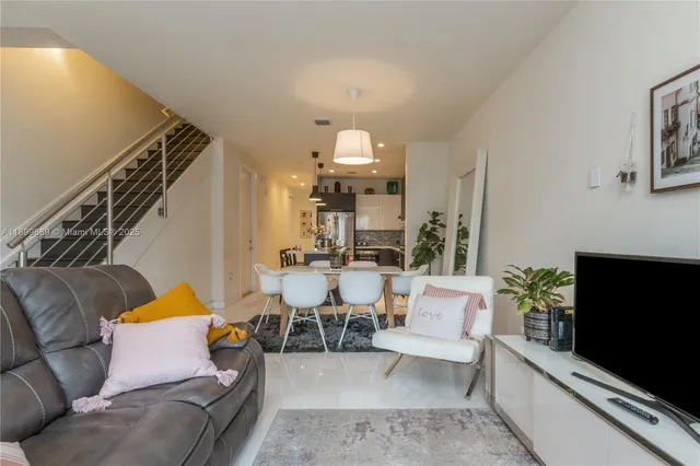 a living room with furniture a flat screen tv and a potted plant