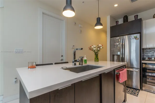 a kitchen with stainless steel appliances a sink and refrigerator