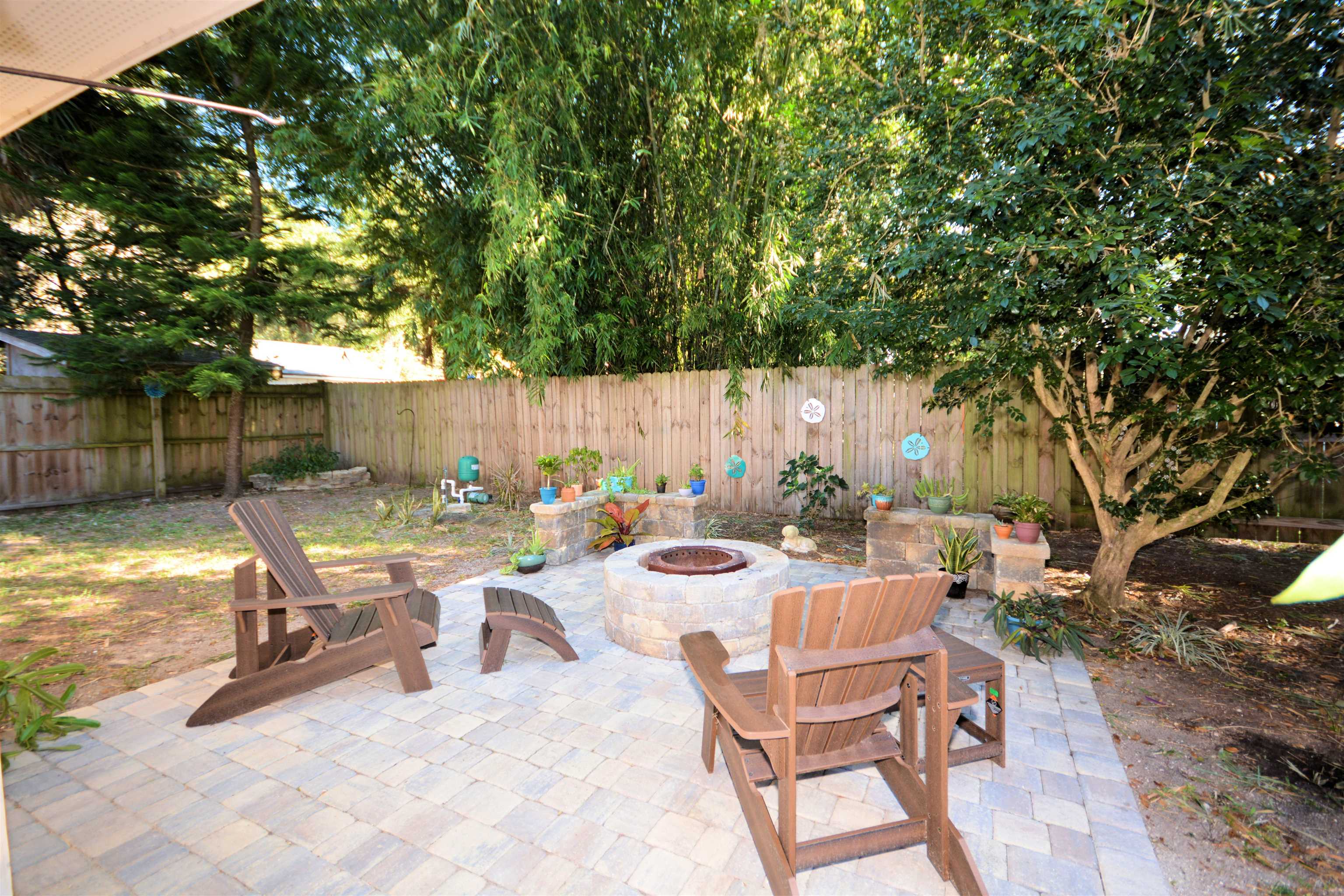 253 Mimosa Road St. Augustine, FL 32086 - Photo 37 of 42 a view of a patio with a dining table and chairs with wooden fence