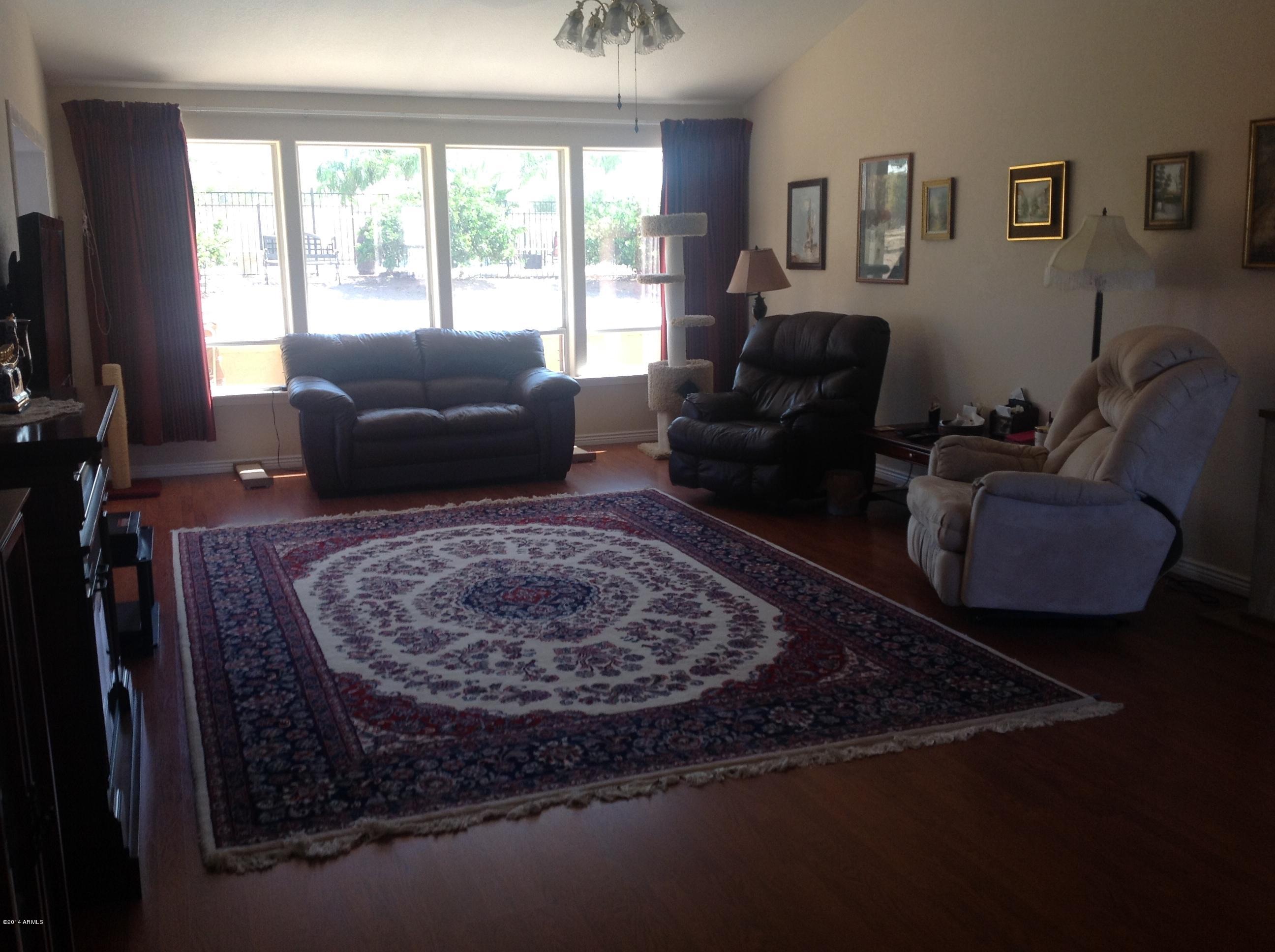 1355 North Acacia Road Apache Junction, AZ 85119 - Photo 16 of 45 a living room with furniture rug and a large window