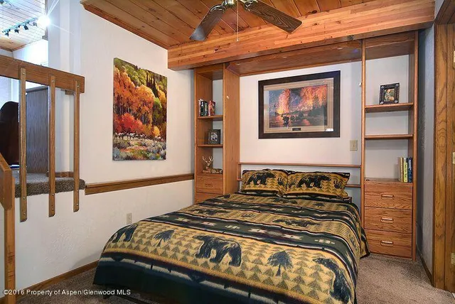 a bedroom with a bed and a painting on the wall