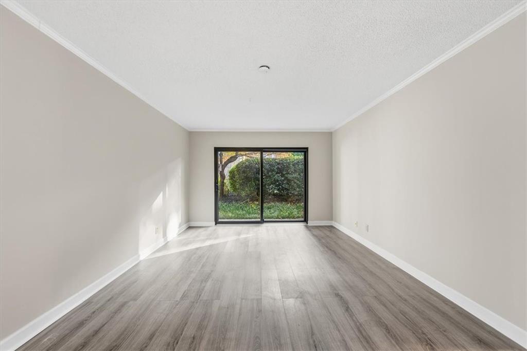 2260 Pernoshal Court Atlanta, GA 30338 - Photo 21 of 46 a view of an empty room with wooden floor and a window