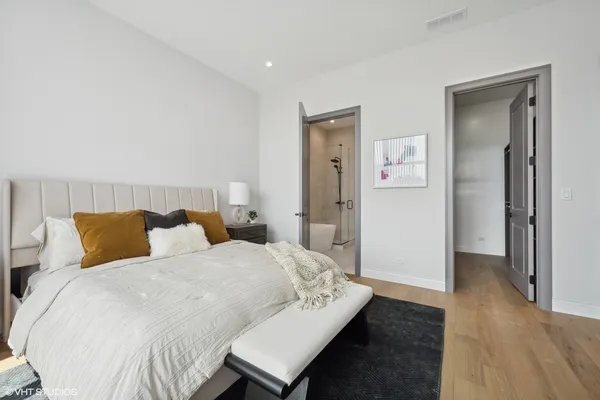 a bedroom with a bed and wooden floor