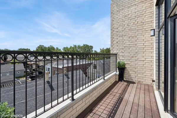 a view of balcony with wooden floor and fence