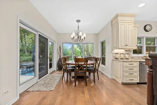 a view of a dining room with furniture a chandelier and wooden floor