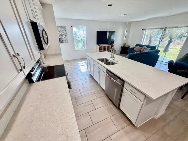 a kitchen with stainless steel appliances a stove sink microwave refrigerator and cabinets