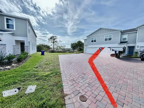a front view of house with yard and trees in the background