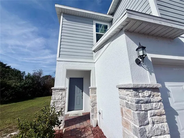 a front view of a house with plants