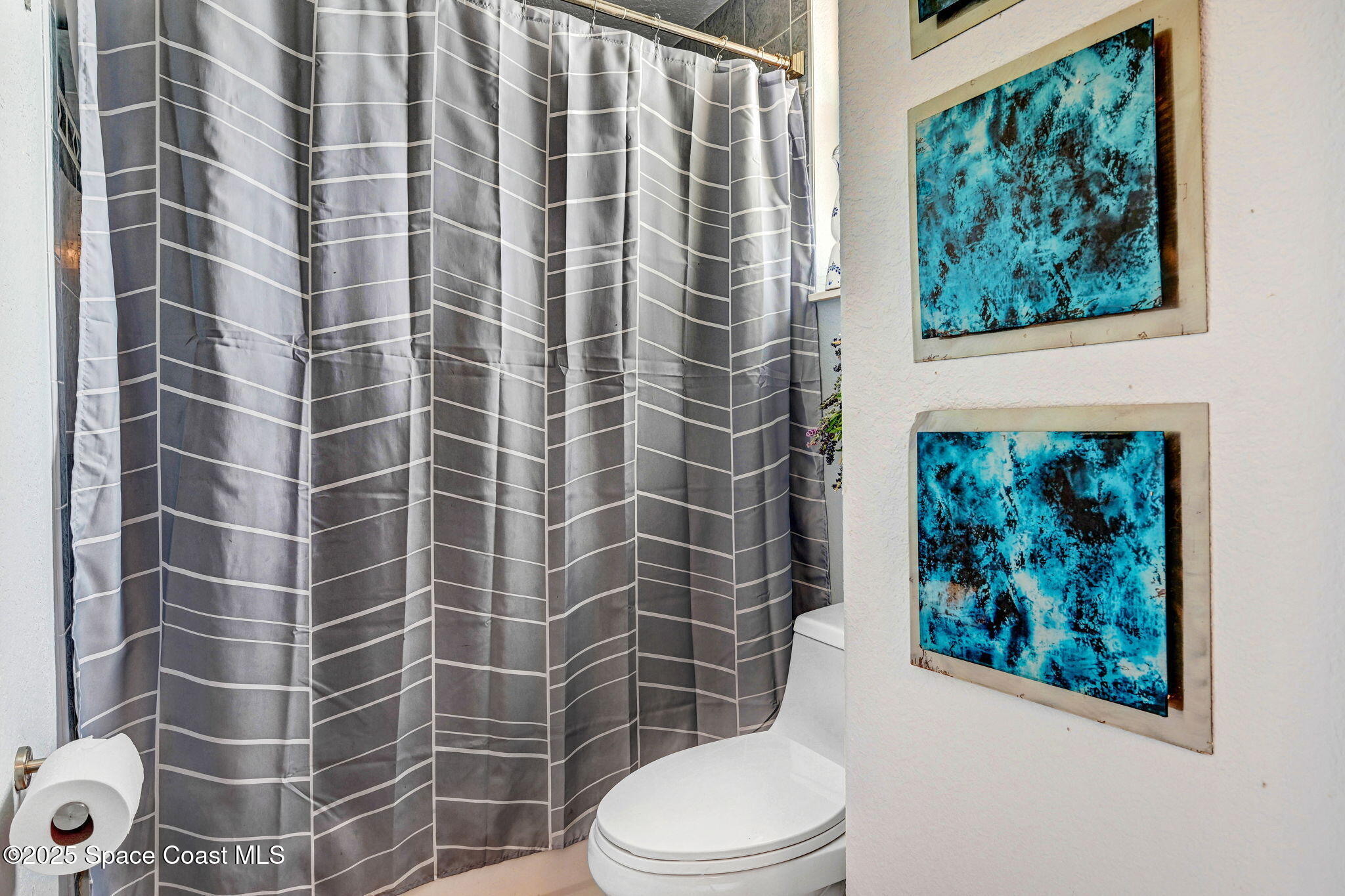 4073 Sand Ridge Drive Merritt Island, FL 32953 - Photo 29 of 66 a bathroom with a toilet and a shower curtain
