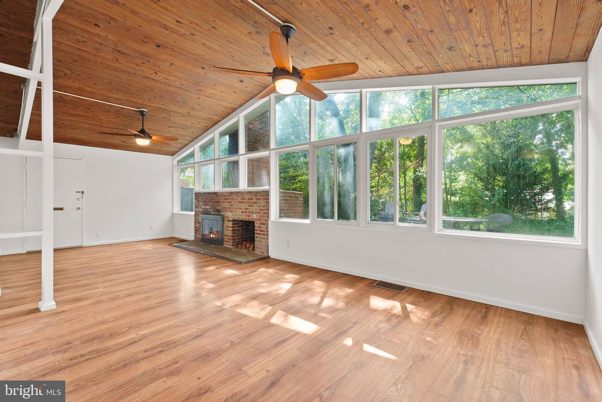 a view of empty room with wooden floor and fireplace
