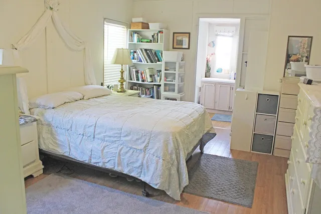 a bedroom with a bed and a wooden floor