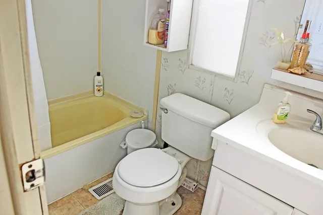 a white toilet sitting next to a bathroom sink and tub