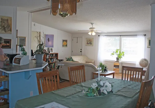 a view of a dining room with furniture a chandelier and wooden floor