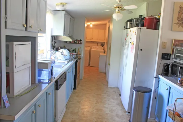 a kitchen with stainless steel appliances granite countertop a refrigerator a stove and a sink
