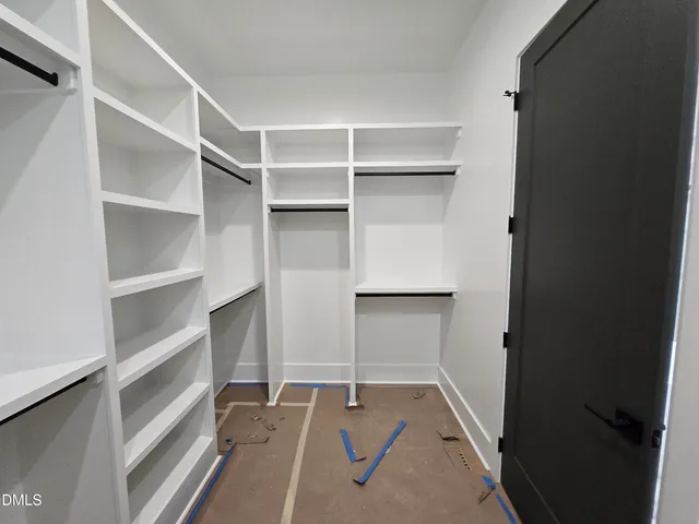 a view of a hallway with wooden floor and chandelier