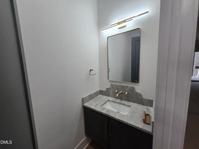 a bathroom with a granite countertop sink and a mirror
