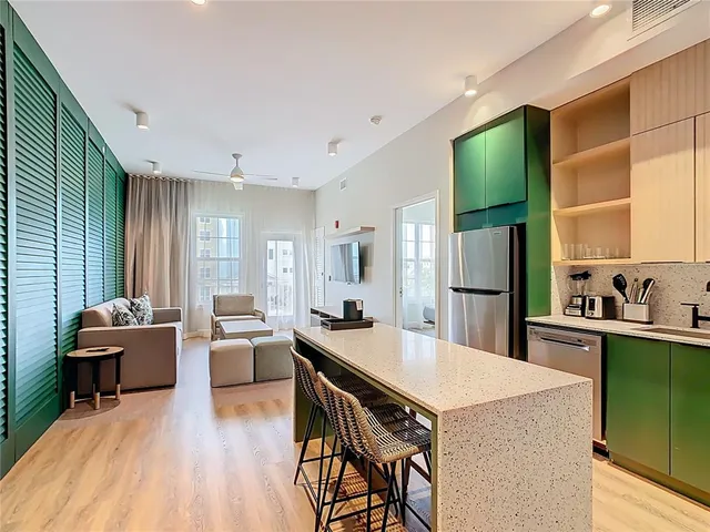 a kitchen with stainless steel appliances kitchen island granite countertop a refrigerator and a stove top oven