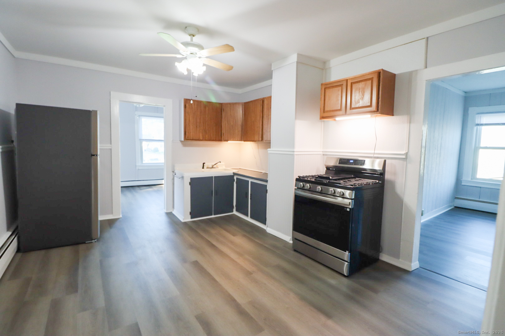 a kitchen with granite countertop a stove cabinets and wooden floor