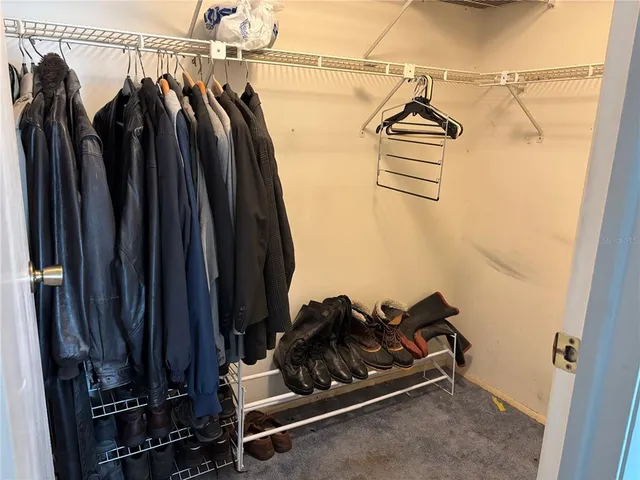a view of walk in closet with clothes and shoes