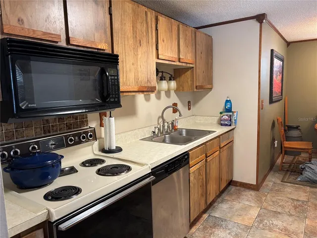 a kitchen with a sink a stove and cabinets